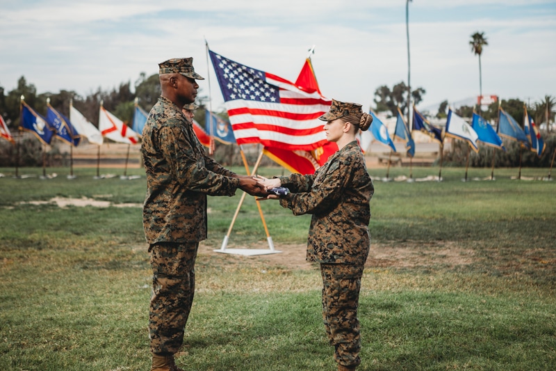 Family Photographer, two soldiers participate in an honors ceremony holding a flag